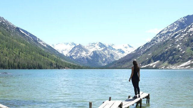 Woman hiker at mountain lake. Woman on the shore of Multinskoye Lake in Altai Mountains, hiking in the mountains