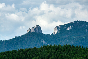 Egyeskő (Lonely Rock) Peak in Romania's Hagymás Nature Reserve, captured in high detail. Dramatic limestone cliffs under summer clouds, perfect for nature, hiking, and travel visuals.