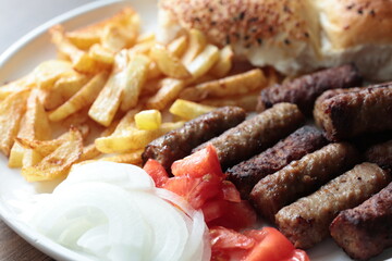 A balkan traditional meatball dish cevapi, cevapcici  on wooden table in close-up	