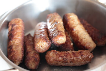A balkan traditional meatball dish cevapi, cevapcici  on wooden table in close-up	