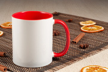 Blank two-tone 11oz mug on on the table. Mug with warm spices like cinnamon, star anise, dried orange. Red handle. Mug mockup