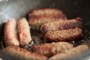 A balkan traditional meatball dish cevapi, cevapcici  on wooden table in close-up	