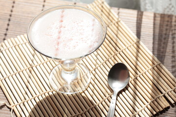 Strawberry pink pudding in glass mug on wooden table close up
