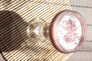 Strawberry pink pudding in glass mug on wooden table close up