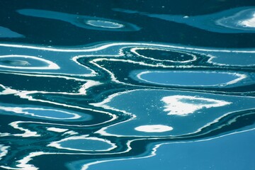 Abstract surface of the blue sea with lines and shine water background