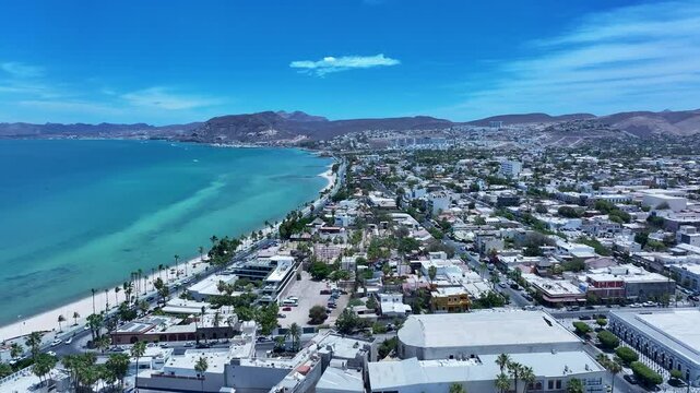 Aerial La Paz Mexico city along ocean bay 2. Capital Mexican state of Baja California Sur, peninsula. Ferry, fishing, cargo and cruise ships. Beach Malecon markets. Eco tourism economy.