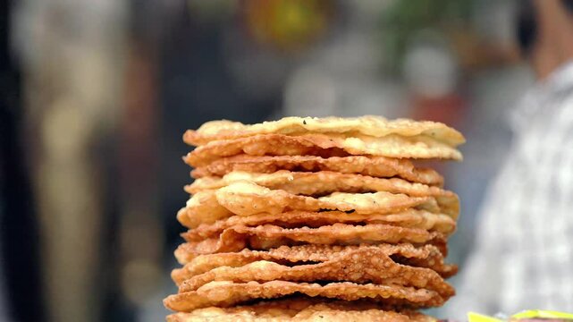Crispy golden-brown papadum stack, a traditional Rajasthani fried snack made from seasoned lentil flour, showcasing authentic Indian street food culture