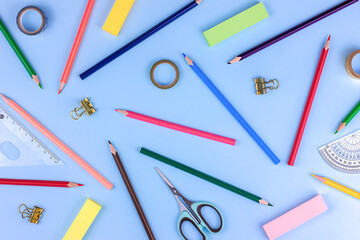 edukation background - colored different stationery on blue background, top view
