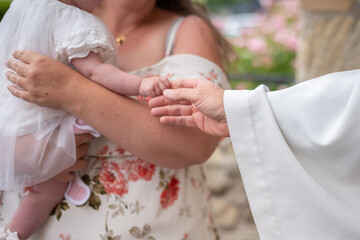 Le prêtre qui tient la main de l'enfant pendant une cérémonie de baptême dans une église