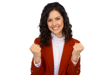 Professional businesswoman with curly hair, donning bright orange jacket, raising fisted hands with triumphant energy, celebrating corporate success against clean white background
