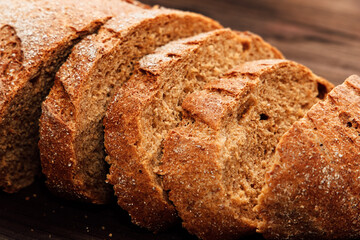 Freshly baked whole grain bread sliced on a wooden board in a cozy kitchen setting