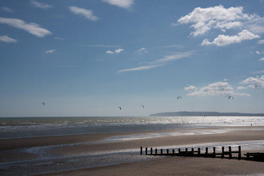 pier on the beach with windsurfers