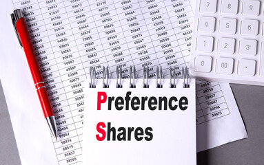 Preference shares text on notepad with financial spreadsheets, red pen and calculator on desk