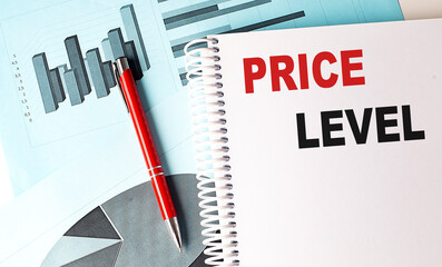 Price level text on spiral notebook with charts and red pen on blue background