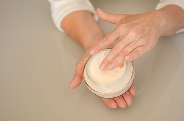 woman picking up moisturizer with her fingers