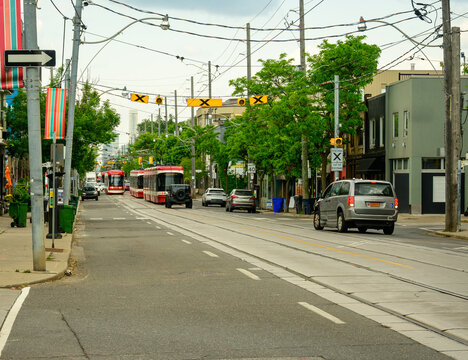 Public transport: a modern light rail tram line on a  busy city street vehicles shot on a sunny morning in Toronto's Leslieville neighbourhood room for text	
