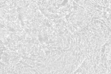 White water with ripples on the surface. Defocus blurred transparent white colored clear calm water surface texture with splashes and bubbles. Water waves with shining pattern texture background.
