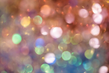 Fototapeta premium Out-of-focus glitter sparkles form a dreamy, radiant bokeh backdrop with warmth and elegant festive atmosphere