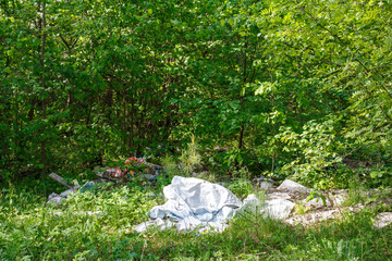 Plastic and polyethylene trash thrown into the thicket of trees