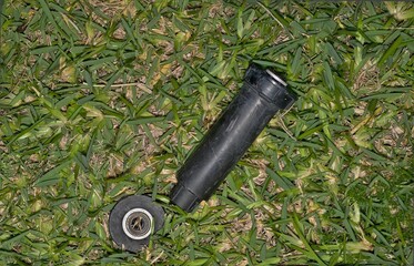 Broken sprinkler head nozzle on lawn from lawnmover accident backyard garden.