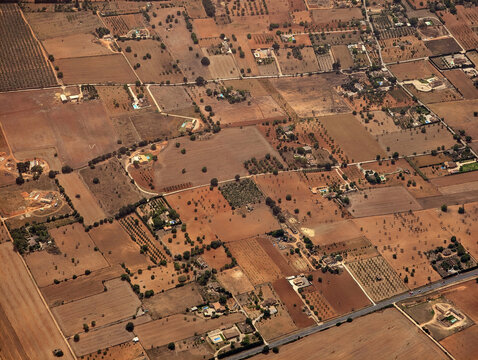 Aerial view of Inca municipality rustic country fincas and houses, rural plots, properties and paths, dryland farmlands and fields, Ma-3240 road, brown ground lands, Mallorca, Balearic Islands.