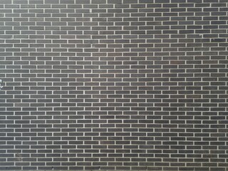 A dark brown brick wall with smooth cement joints. Space for creative text, advertising. Copy space 