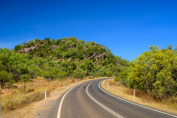 Naklejka premium Endless horizons and dusty solitude—journeying through the vast, remote roads of Outback Australia where silence, space, and red earth rule the landscape.
