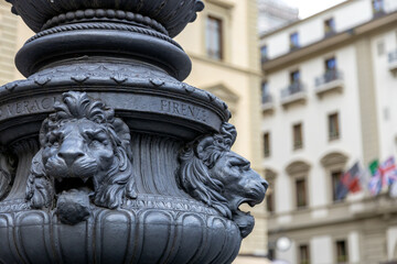 Naklejka premium Close-up of lion head ornaments on a cast iron lamp post in Piazza della Repubblica, Florence - a historic detail in the heart of Tuscany