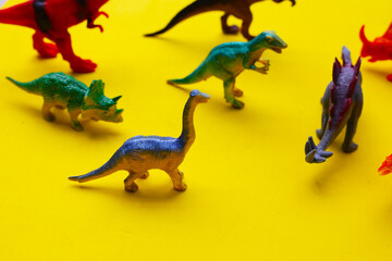 Plastic dinosaur toys on yellow background