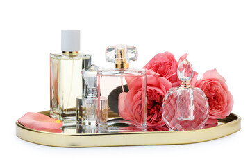 Many different perfume bottles and roses isolated on white