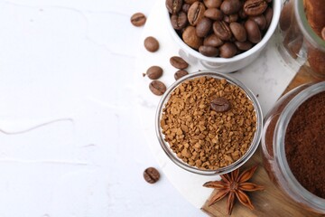 Different types of instant coffee, beans and spices on light textured table, top view. Space for text