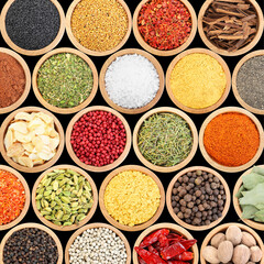 Set of different aromatic spices in bowls on black background, flat lay