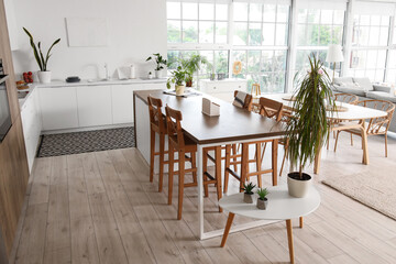 Interior of light open plan kitchen with dining table and island