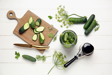 Jar with fresh cucumbers and ingredients for canning on white wooden background