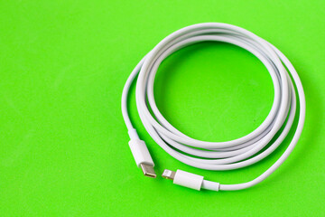 Cable with Type-C connector insulated, charging cable coiled on a green background.