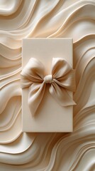 Beige gift box with satin bow on wavy fabric