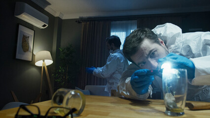 Crime scene investigators collecting evidence with flashlight