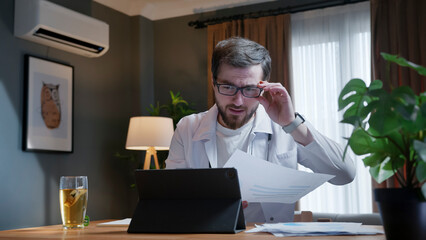 Doctor reviewing documents during online consultation