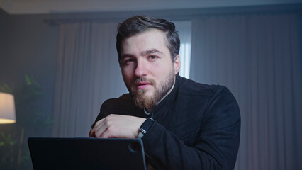 Confident man in black jacket at desk