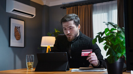 Man shopping online with credit card at home
