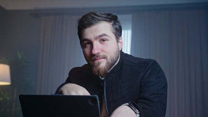 Confident man smiling while working on laptop