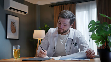 Doctor writing notes during remote consultation
