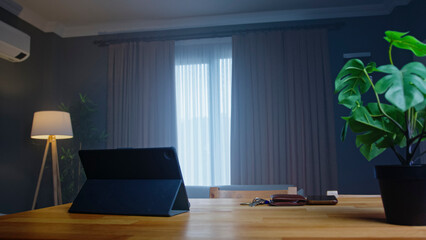 Empty home office desk with tablet and window