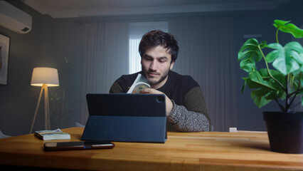Holds up a stack of cash while speaking to the camera in a professional home office. Investment, cryptocurrency, and wealth management