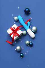Vibrator with gift box and Christmas decor on blue background