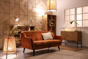 Interior of stylish living room with glowing lamps and sofa at night