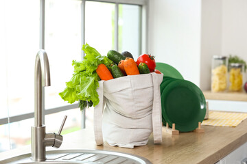 Shopping bag with products near sink in kitchen