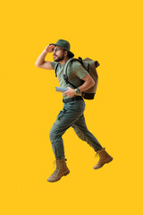 Jumping male traveler on yellow background