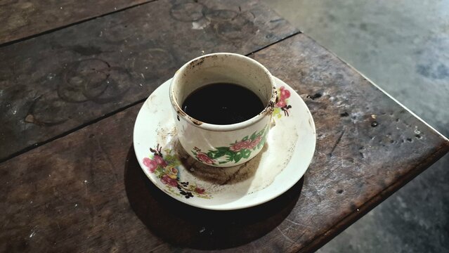 Cup of Black Coffee on Rustic Wooden Table: Simple Coffee Mug and Saucer on a Textured Wood Surface, Morning Drink	 - Powered by Adobe