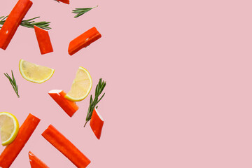 Tasty crab sticks with rosemary and slices of lemon flying on pink background © Pixel-Shot